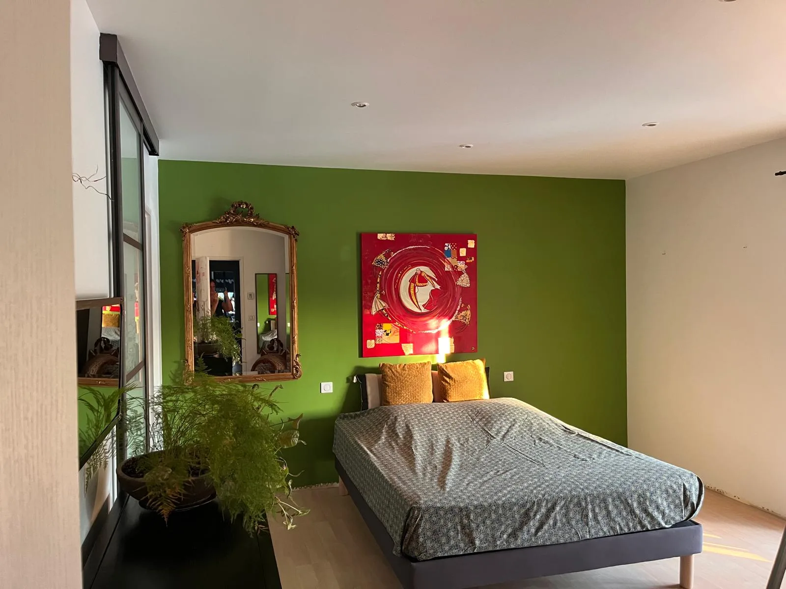 Chambre rénovée avec parquet naturel flottant et mur vert matcha à Bouloc